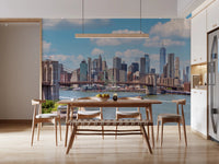NYC Bridge Vista wallpaper mural of the Brooklyn Bridge behind a wooden dining table and chairs in a bright kitchen