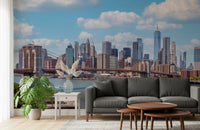 NYC Bridge Vista wallpaper mural of the Brooklyn Bridge and Manhattan skyline behind a charcoal sofa in a living room