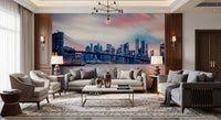 NYC Twilight Dreams wallpaper mural of the pink dusk skyline behind two grey sofas and a gold chandelier