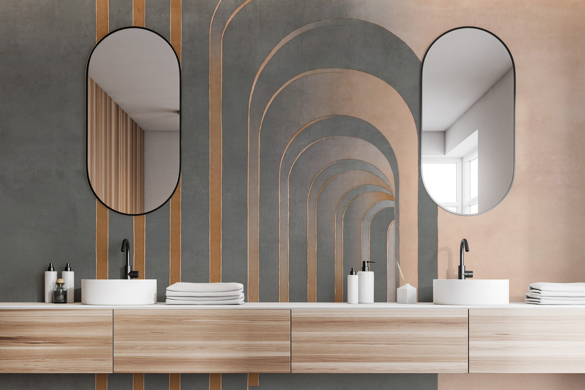 Modern Grey Textured wallpaper mural with grey arches and copper lines above a wood double vanity and oval mirrors in a bathroom