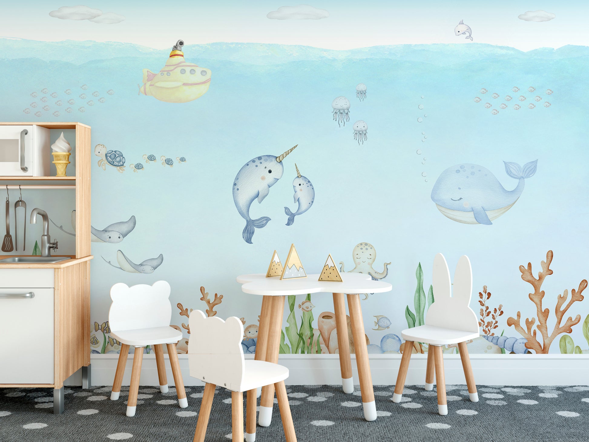 Ocean Explorer Watercolor wallpaper over a toy kitchen and white bear and bunny chairs in a child's playroom