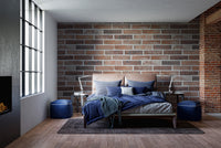 Old Dirty Red Brick wallpaper mural in an industrial bedroom behind a bed with blue bedding and blue poufs