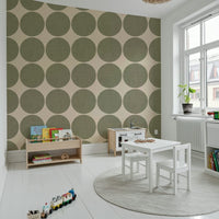 Beige wallpaper decorated with large olive dots that have a subtle fabric-like texture