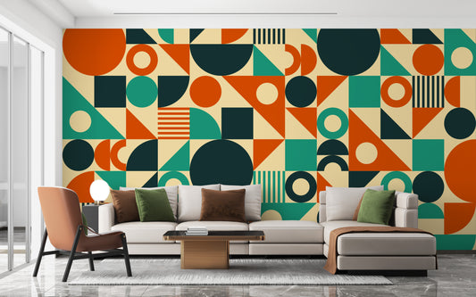 Orange & Green Mid Century wallpaper mural of geometric shapes behind a beige sectional sofa and brown chair in a living room