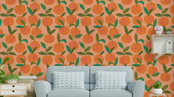 Orange Grove wallpaper of painted oranges and leaves behind a light blue sofa with dotted cushions
