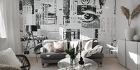 Urban Newsprint wallpaper mural in monochrome newspaper print behind a grey sofa and tripod lamp in a living room