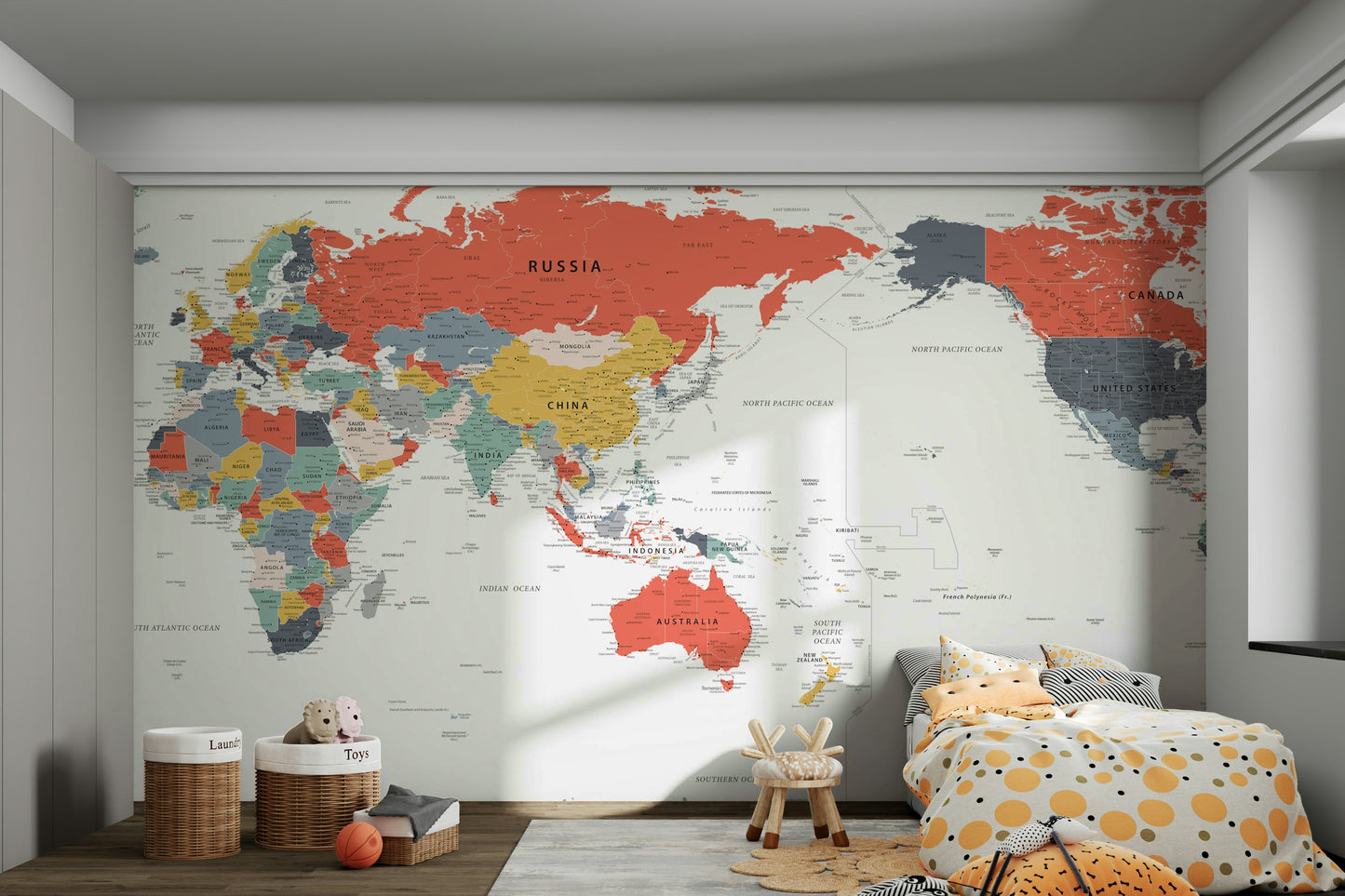Pacific Centered World Map in Happy Colors wallpaper mural over a low bed with polka-dot bedding and toy baskets