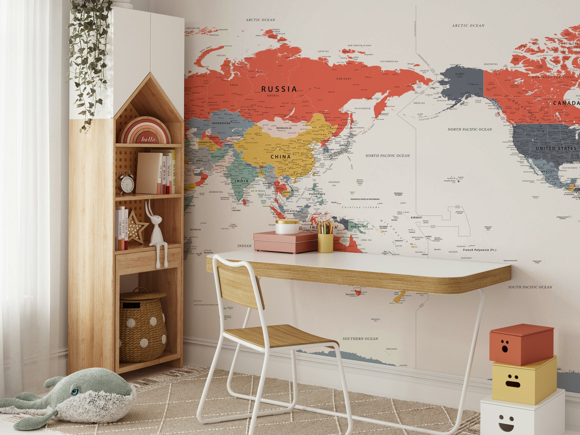 Pacific Centered World Map in Happy Colors wallpaper mural behind a white desk and house-shaped bookshelf