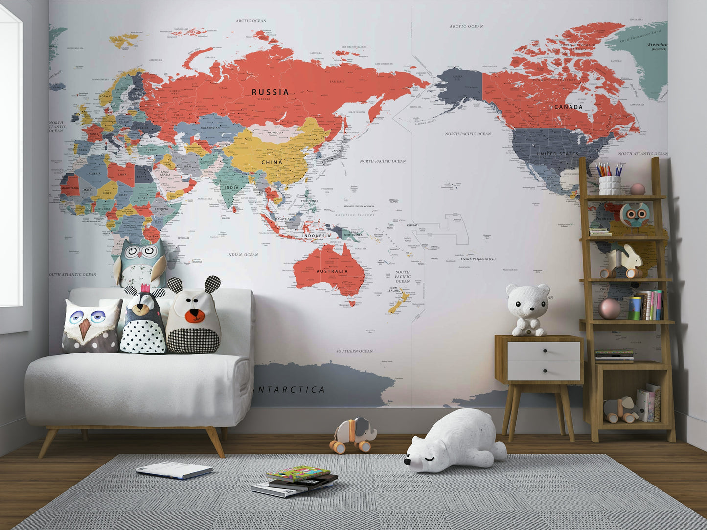Pacific Centered World Map in Happy Colors wallpaper mural over a white loveseat with owl pillows and a polar bear toy