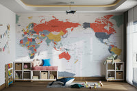 Pacific Centered World Map in Happy Colors wallpaper mural above a pink bench and cube shelves with a whale plush