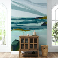 The mural is installed in a calm living room behind a simple, light-colored sofa.

