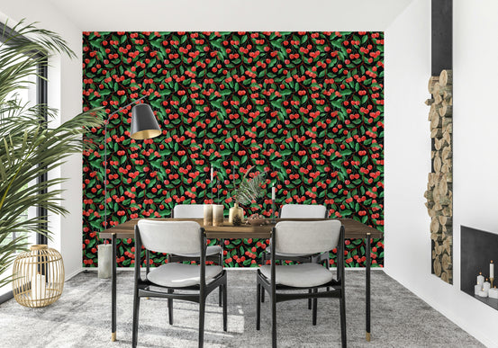 Painterly Cherries Black wallpaper with red cherries and green leaves behind a wooden dining table and gray chairs