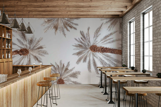 A wall mural of a view looking up at palm trees.

