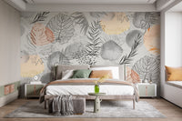 Palm tropical leaves wallpaper mural in grey and terracotta behind a bed with a grey upholstered headboard