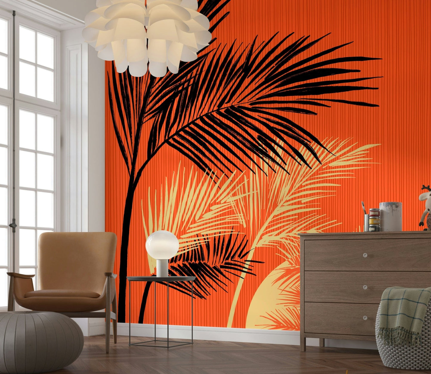 Palms at Sunset wallpaper mural of bold palm fronds on orange beside a tan armchair and wood dresser