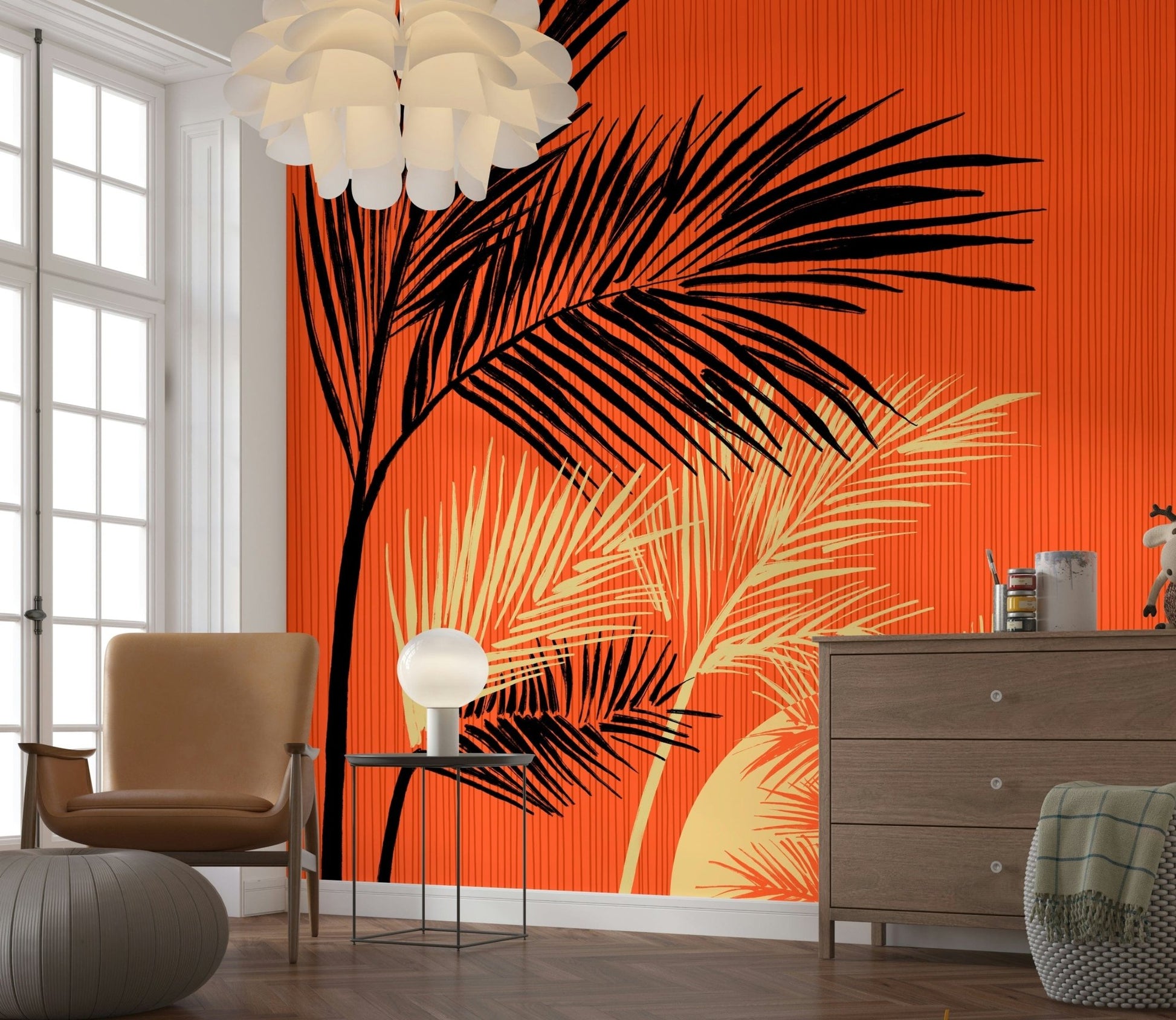 Palms at Sunset wallpaper mural of bold palm fronds on orange beside a tan armchair and wood dresser
