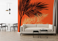 Palms at Sunset wallpaper mural with black and cream palms on orange behind a cream sofa and black side tables