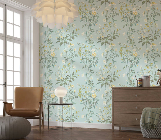Pastel Botanical Dream wallpaper mural with mint green and yellow florals behind a tan armchair and wood dresser