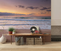 Peace at the Beach wallpaper mural of golden dusk waves in an entryway with a wood bench, vinyl records and baskets