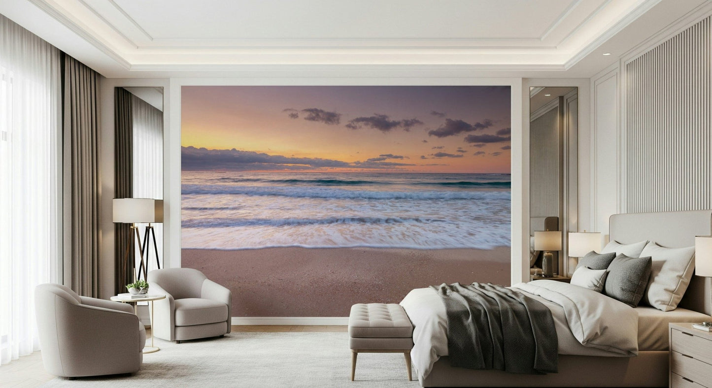 Peace at the Beach wallpaper mural of a sunset sea above a beige bed and two cream tub chairs in a bedroom