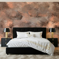 Subtle Canvas wallpaper mural in peach and grey above a black tufted bed with gold-accented bedding in a bedroom