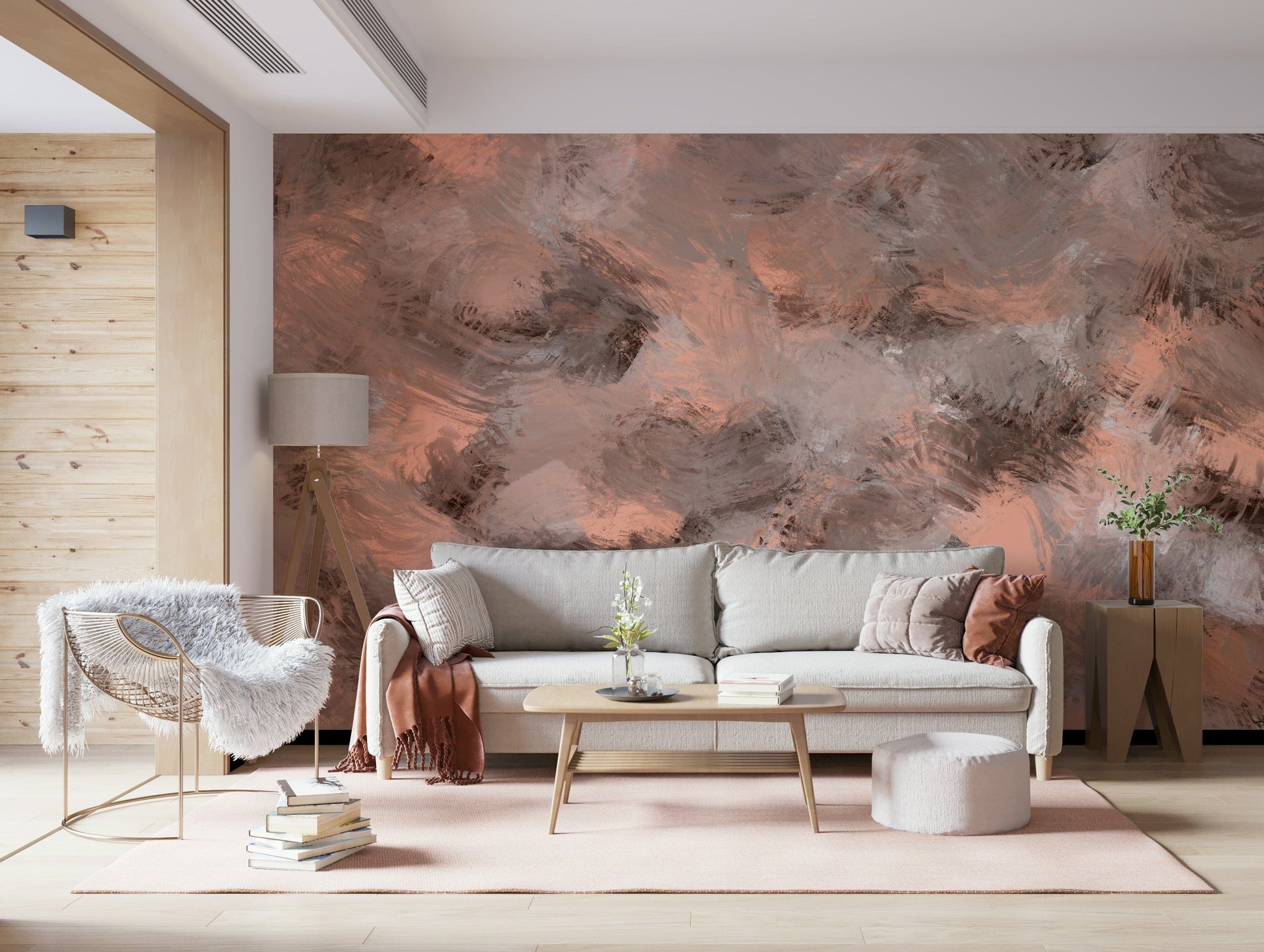 Subtle Canvas wallpaper mural in peach and grey behind a grey sofa and rattan chair in a warm living room