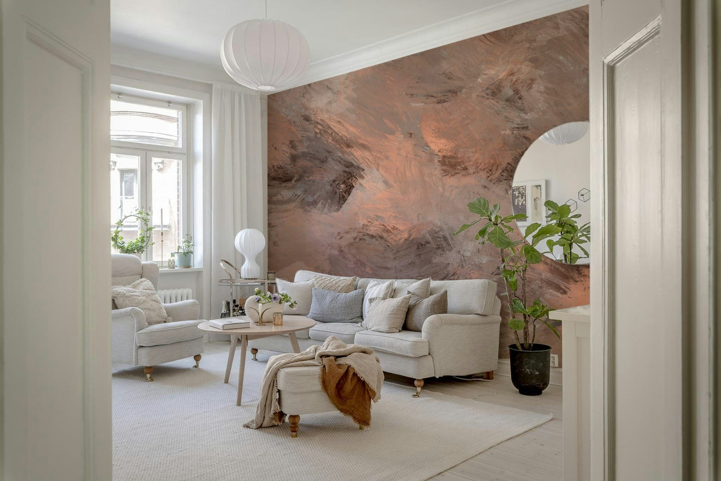 Subtle Canvas wallpaper mural in soft peach and grey behind a cream sofa and paper lantern in a bright living room