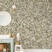 Pear Blossom White Flowers wallpaper mural in a green bathroom with a round mirror and white vanity sink