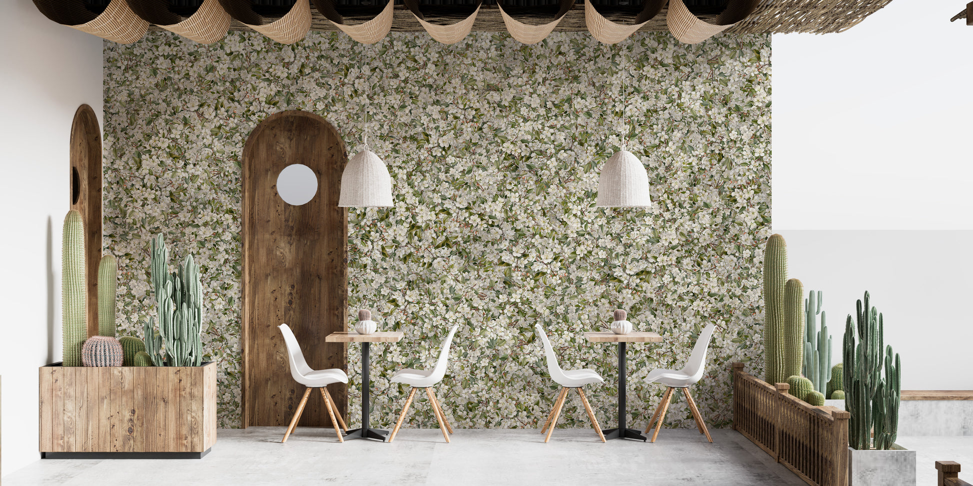 Pear Blossom White Flowers wallpaper mural in a cafe with white chairs, potted cacti and an arched wood door