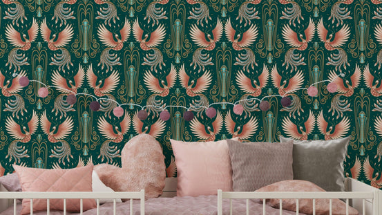 Rebirth of a Phoenix Green wallpaper with coral phoenix birds on teal behind a white crib and pink cushions in a nursery