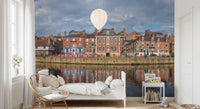 Picturesque Riverfront Wall Mural with historic brick buildings and water