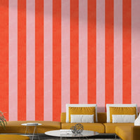 Pink and Red Stripes Linen Texture wallpaper behind a mustard sectional sofa with white pillows in a lounge