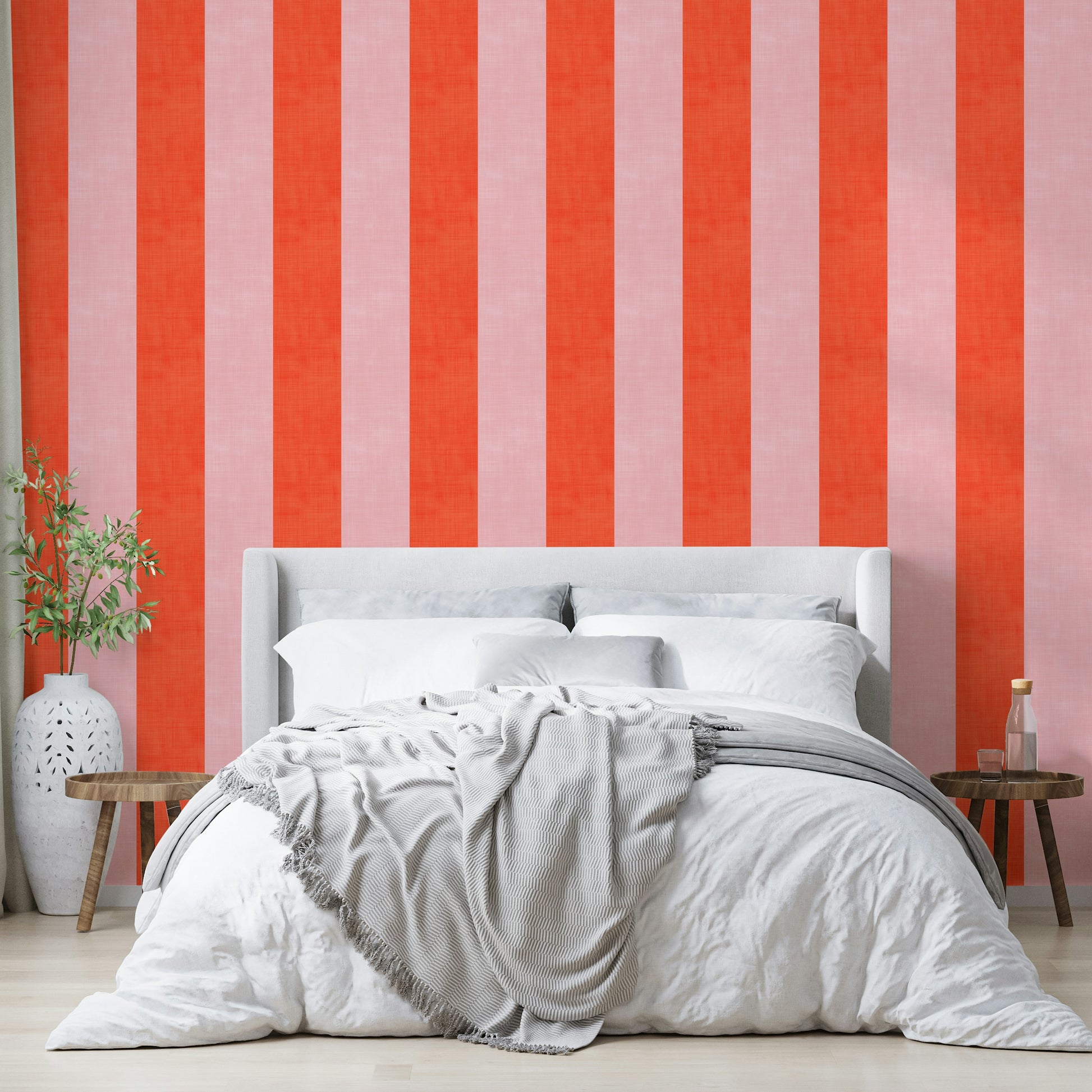 Pink and Red Stripes Linen Texture wallpaper above a gray upholstered bed with white bedding in a bedroom