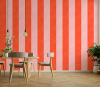 Pink and Red Stripes Linen Texture wallpaper behind a wood dining table with beige chairs and pendant bulbs
