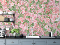 Pink Begonia Flower wallpaper mural above grey kitchen cabinets and a black counter with a coffee machine and plant
