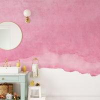 Pink shades watercolor wallpaper in a kids bathroom with a mint vanity, round mirror and rubber ducks