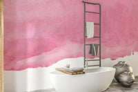 Pink shades watercolor wallpaper behind a freestanding white tub and towel ladder in a modern bathroom
