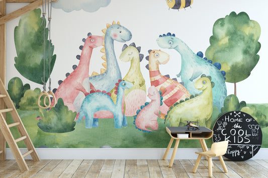Playful watercolor dinosaur wallpaper mural in pastel colors in a kids playroom with gym rings and a chalkboard sign