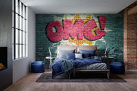 Pop Art OMG Graffiti wallpaper mural on teal brick behind a bed with navy bedding in an industrial bedroom
