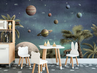Pretty Planets wallpaper mural of a starry sky and planets behind a white play kitchen and animal-ear chairs in a kids room