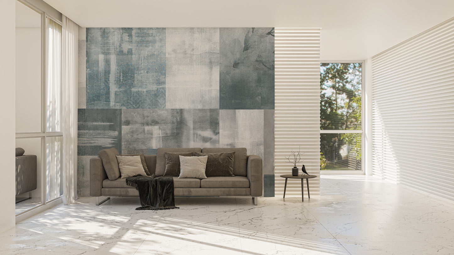 Vintage Elegance wallpaper mural in soft grey-blue tones behind a taupe sofa in a bright marble-floored living room