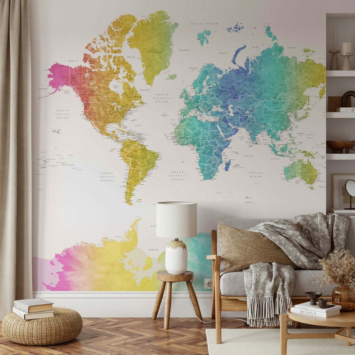 Rainbow World Map wallpaper in rainbow watercolor behind a wood sofa with mustard cushion and a lamp on a stool in a lounge