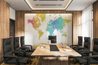 Rainbow World Map wallpaper in rainbow watercolor behind a long wood conference table and black chairs in a boardroom