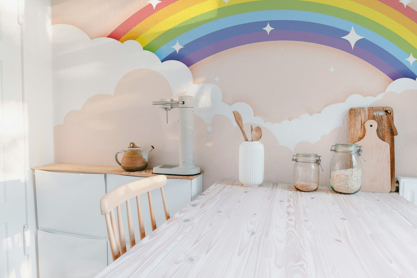 Colorful Rainbow wallpaper mural styled as a feature wall behind a dining table and chairs in a multicolour palette