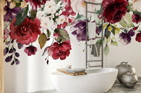 Red and Pink Floral wallpaper mural of roses cascading above a white bathtub in a bathroom