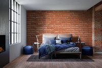 Rustic brick pattern wallpaper in a home  with red metal shelving.