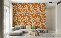 Playful starburst floral wallpaper with cream bursts on a rich burnt orange field.
