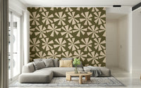 Abstract geometric wallpaper with cream pinwheel motifs on a vintage olive background.
