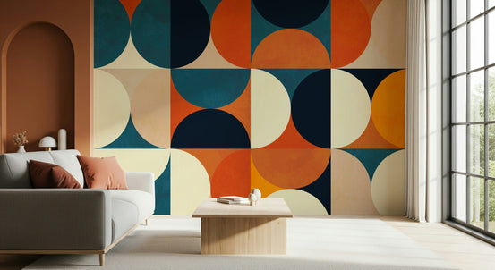 Retro Circles wallpaper mural in teal and orange behind a gray sofa with a terracotta arch