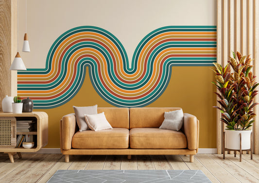 Retro Curvy Lines 2 wallpaper mural in teal and orange waves on mustard behind a tan leather sofa and wood console
